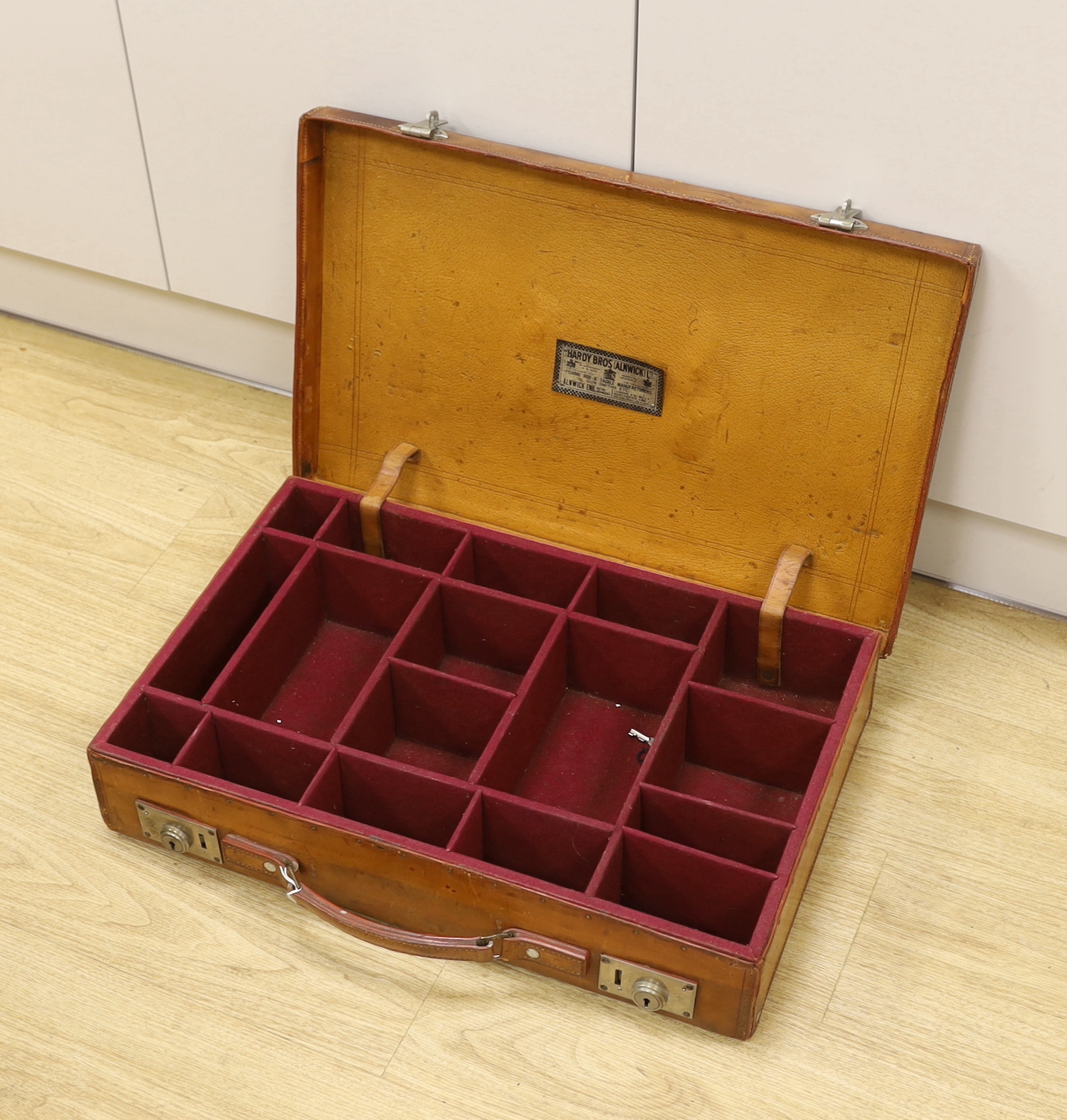 An early 20th century Hardy Bros. Alnwick tan leather fishing reel case, 58cm max.